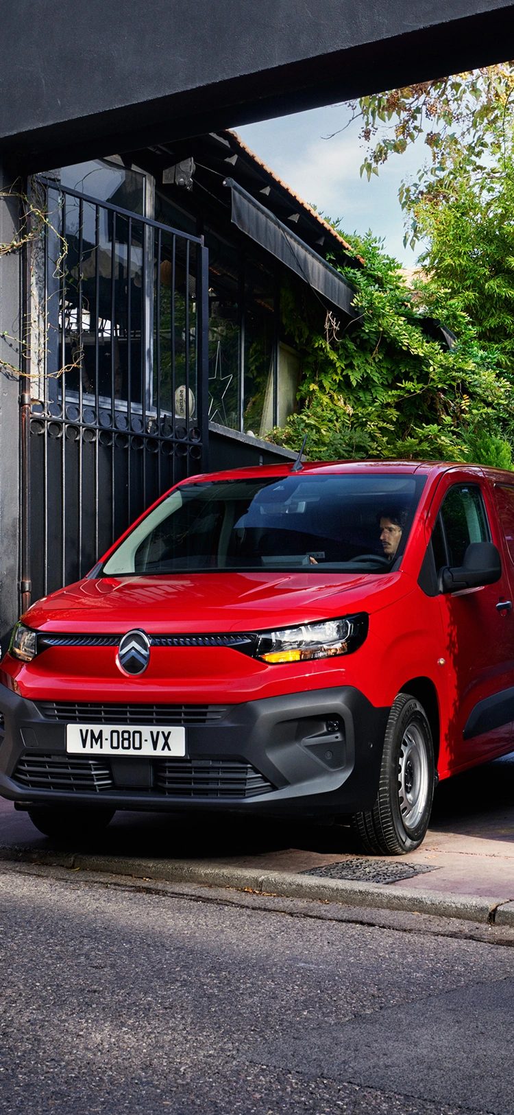 Vista frontal de três quartos de um Citroën ë-Berlingo Van a carregar, exibindo um design elétrico moderno, praticidade para o dia a dia, conectividade e uma presença confiante.
