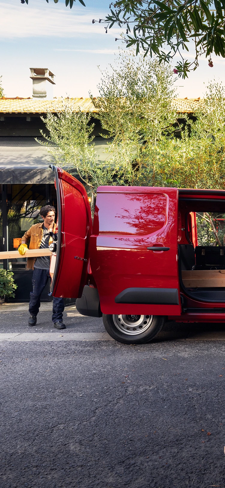 Vista lateral de um Citroën Berlingo Van com a porta deslizante aberta, exibindo versatilidade, praticidade e adequação às atividades profissionais do dia a dia.