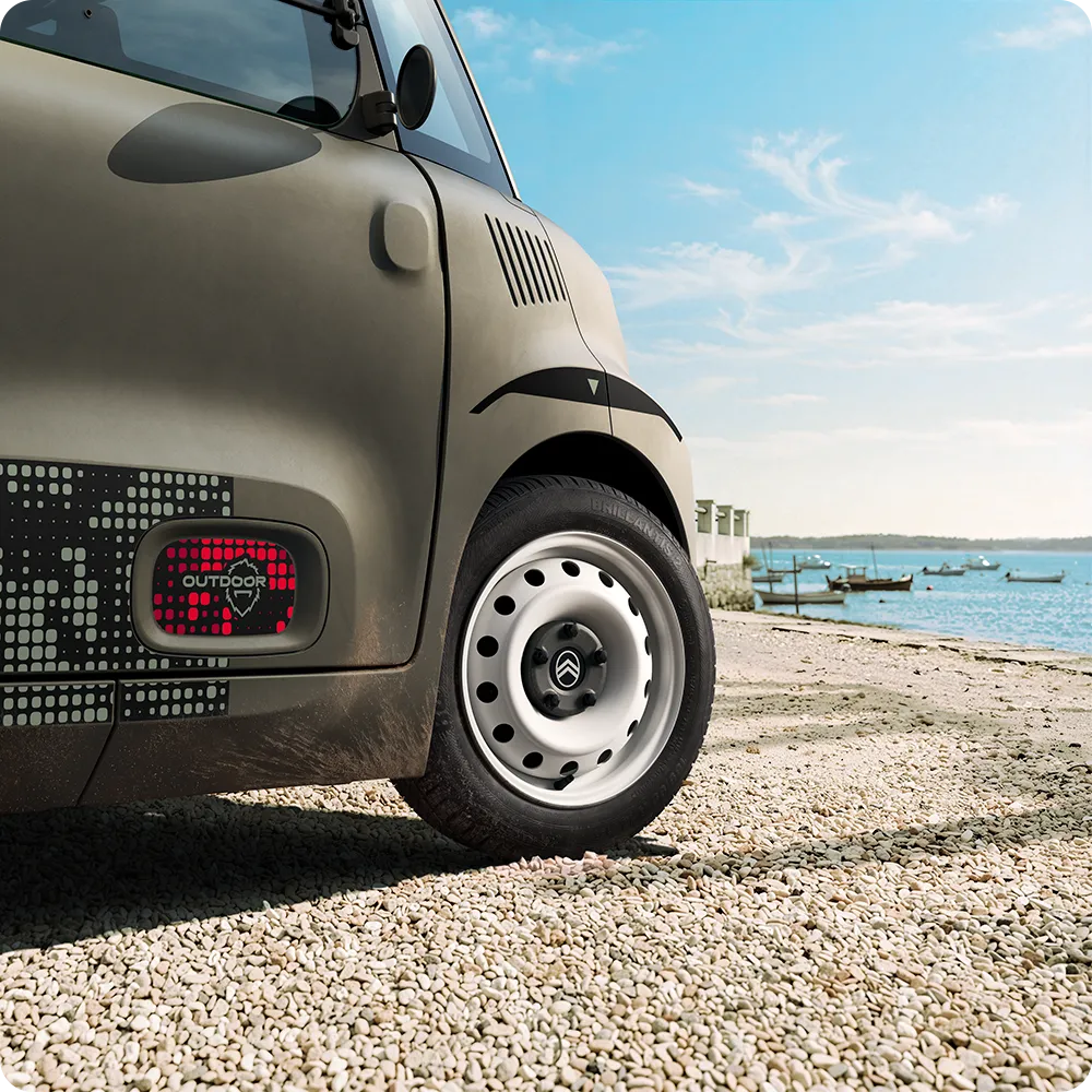 Vista em grande plano das rodas do Citroën ami Outdoor com jantes de aço brancas apresenta um automóvel urbano elétrico compacto para a mobilidade diária
