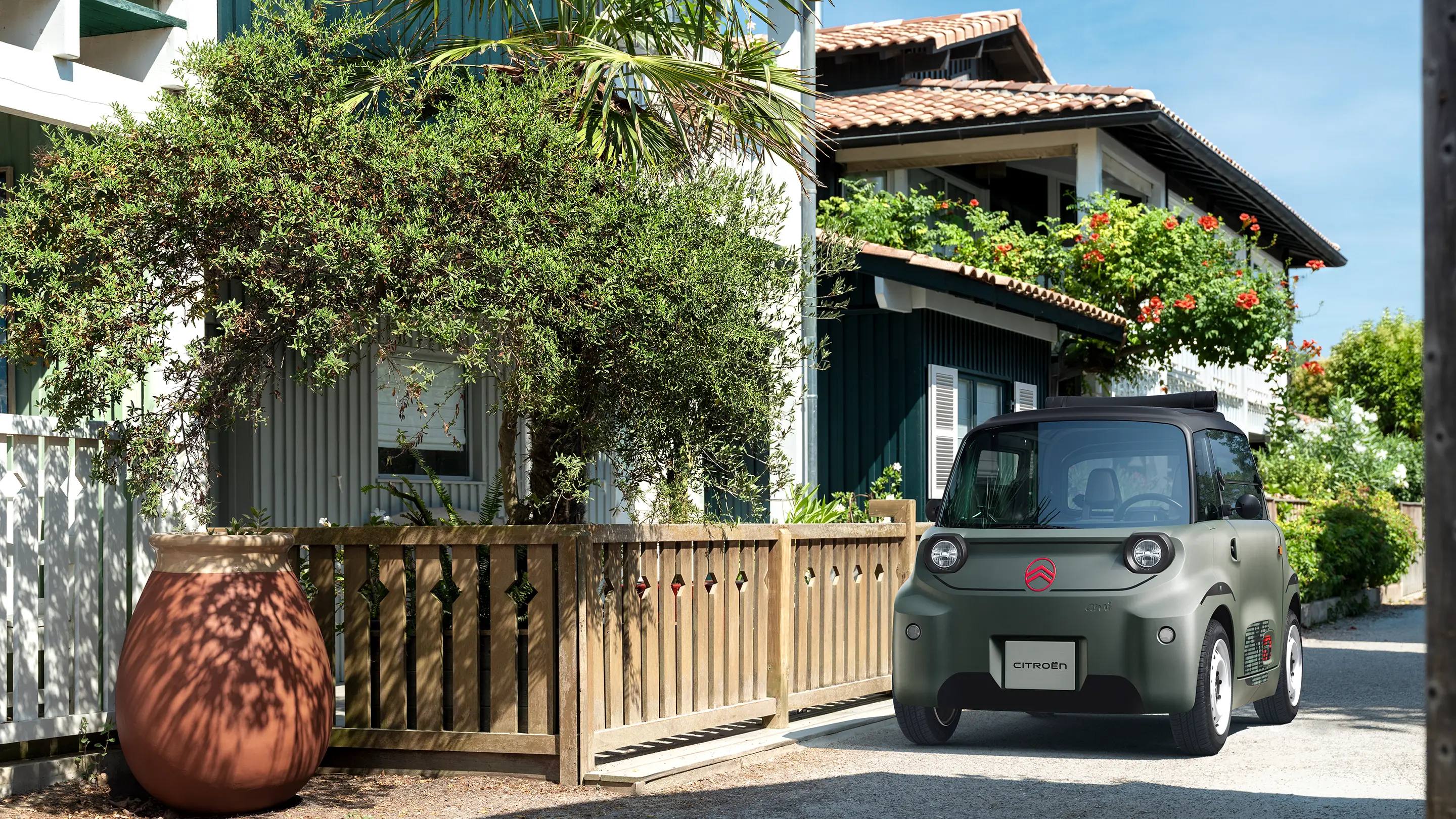 Vista traseira superior do Citroën ami Outdoor com teto preto abrível, que mostra um automóvel urbano elétrico para mobilidade ao ar livre