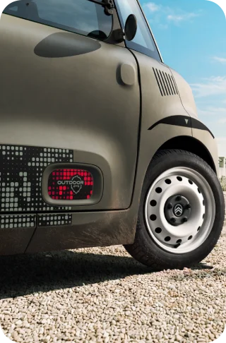 A vista em grande plano das jantes de aço brancas do Citroën ami Outdoor mostra um automóvel urbano elétrico compacto para a mobilidade diária