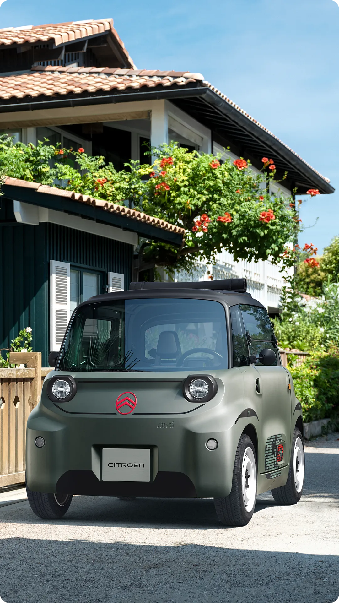 Vista frontal de três quartos do Citroën ami Outdoor com teto flexível, apresentando um automóvel urbano elétrico para mobilidade no bairro
