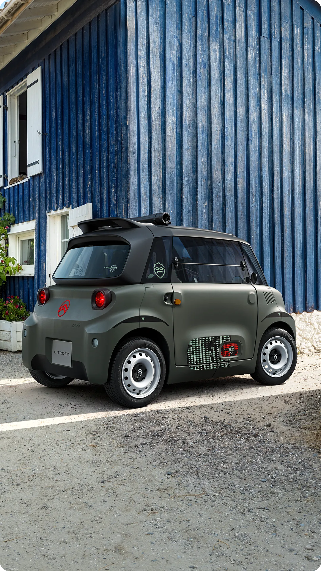 Vista de três quartos frontal do Citroën ami Outdoor com teto de lona, que apresenta um automóvel urbano elétrico para a mobilidade urbana do dia a dia