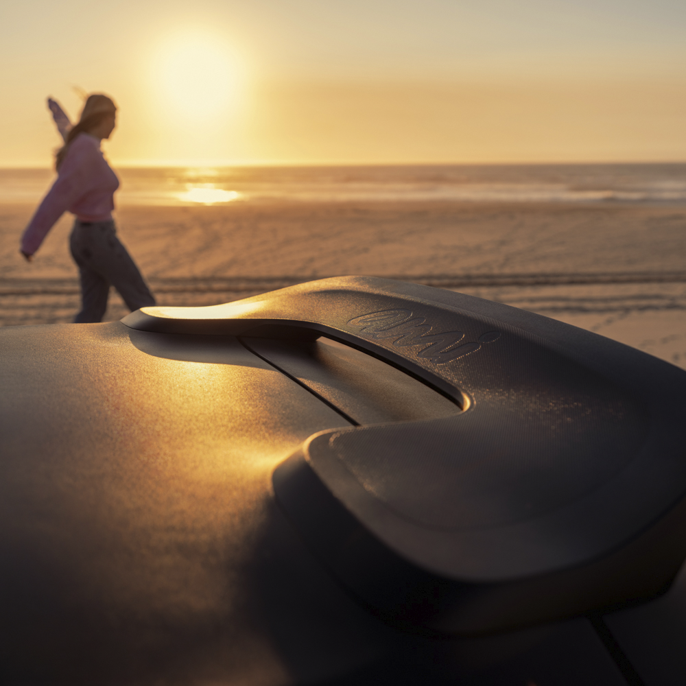 Vista em grande plano da pega do tejadilho ao pôr-do-sol do Citroën Ami x Rip Curl elétrico , Citroën Ami: estilo de vida de praia para um carro elétrico urbano