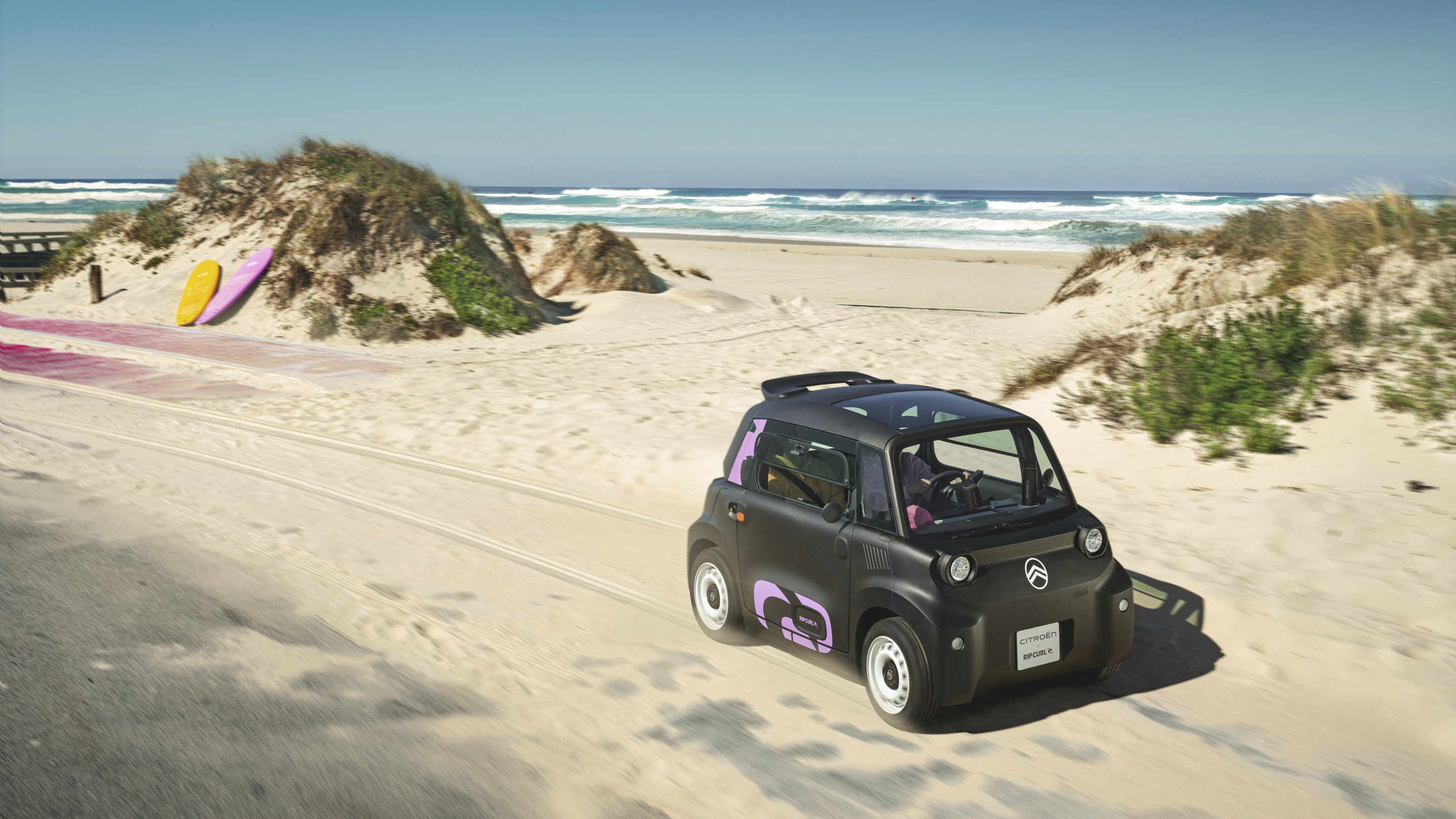 Vista frontal de três quartos em movimento do Citroën Ami x Rip Curl elétrico, a liberdade do Citroën Ami para o carro elétrico urbano