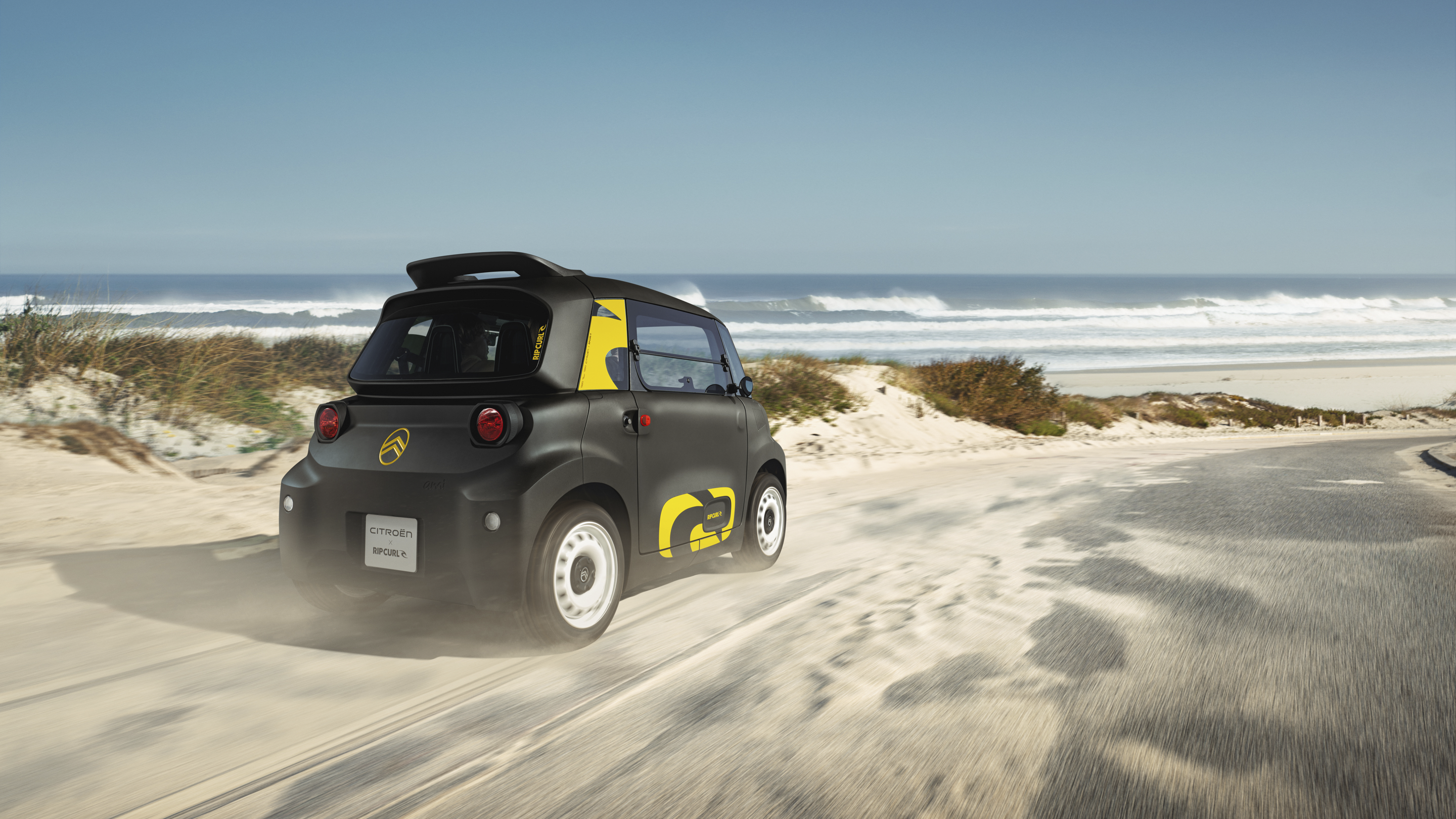 Vista traseira de três quartos em ação do Citroën Ami x Rip Curl elétrico, liberdade do Citroën Ami para mobilidade urbana elétrica