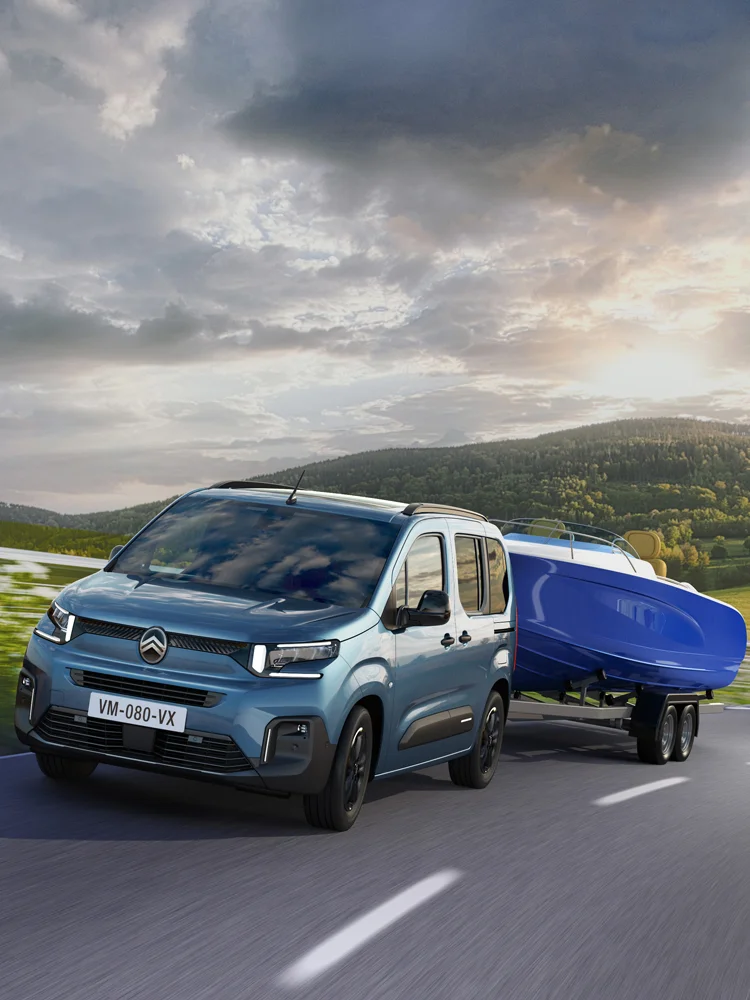 Vista frontal do ë‑Berlingo a rebocar um atrelado com sistema Trailer Stability Control, garantindo maior estabilidade e segurança durante a condução.