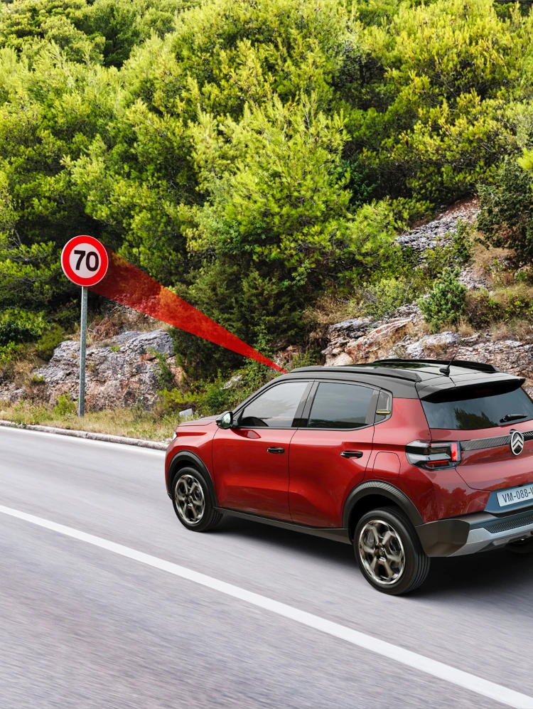 Vista lateral da condução do SUV Citroën C3, mostrando o reconhecimento de limites de velocidade para uma mobilidade diária mais segura, confiante e acessível.