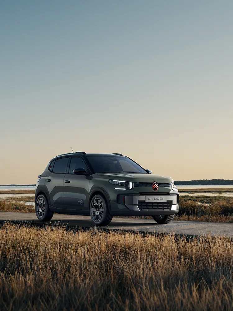 Vista frontal de três quartos do Citroën C3 Outdoor com assinatura LED, apresenta o SUV Advanced Comfort junto a zonas húmidas costeiras
