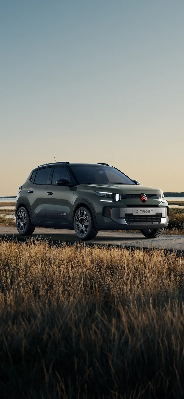 Vista frontal de três quartos do Citroën C3 Outdoor com assinatura LED, apresenta o SUV Advanced Comfort junto a zonas húmidas costeiras