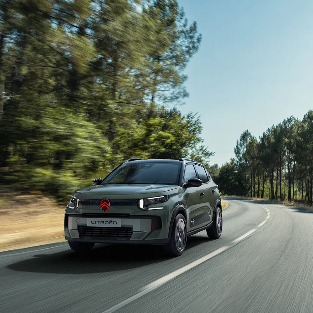 A vista frontal de três quartos do Citroën C3 Outdoor, com a assinatura de luzes LED, ilustra o Citroën Advanced Comfort num percurso panorâmico