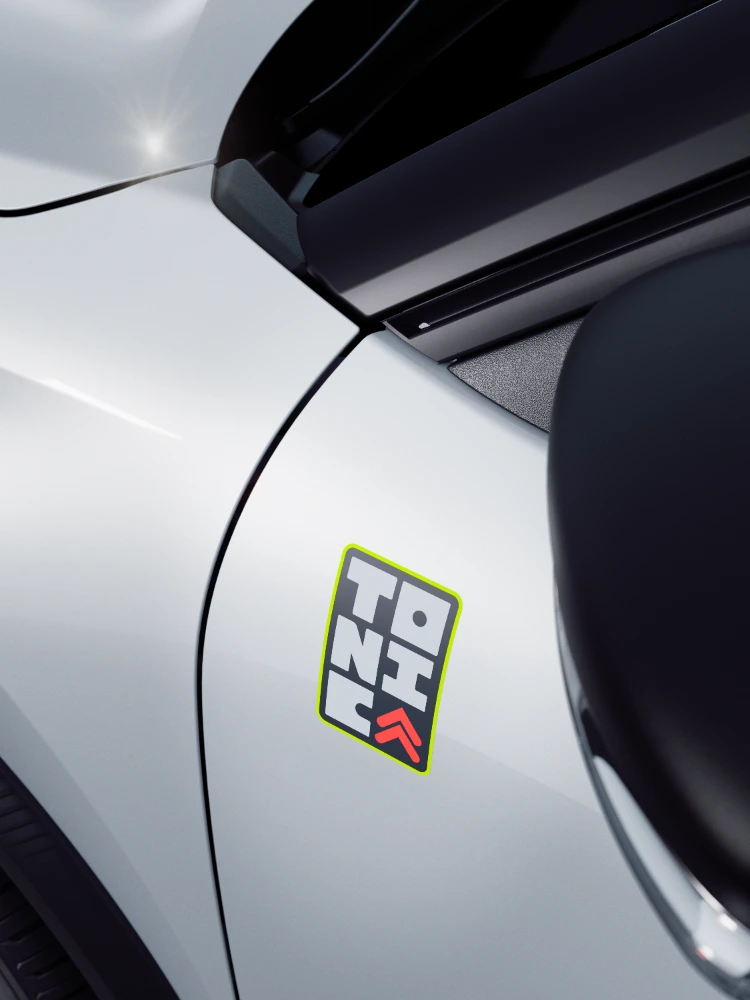 Vista frontal detalhada do Citroën ë-C3 TONIC, edição limitada, automóvel elétrico urbano, com grelha característica e detalhes coloridos, uma alternativa distinta de veículo elétrico