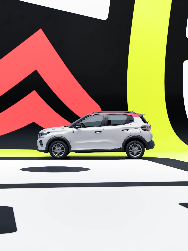 Vista de perfil lateral do Citroën ë-C3 TONIC, edição limitada, carro elétrico urbano conduzido num cenário de estúdio, design compacto, alternativa de veículo elétrico inteligente