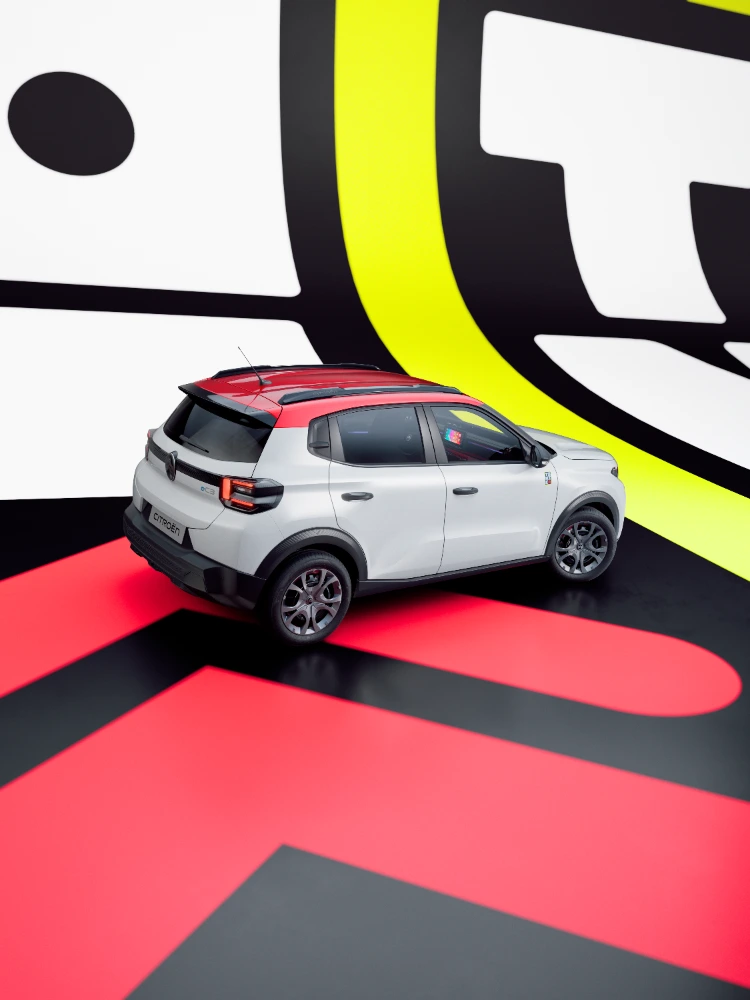 Vista traseira de três quartos do Citroën ë-C3 TONIC, edição limitada, carro elétrico urbano: design arrojado num cenário de estúdio, alternativa de veículo elétrico inteligente