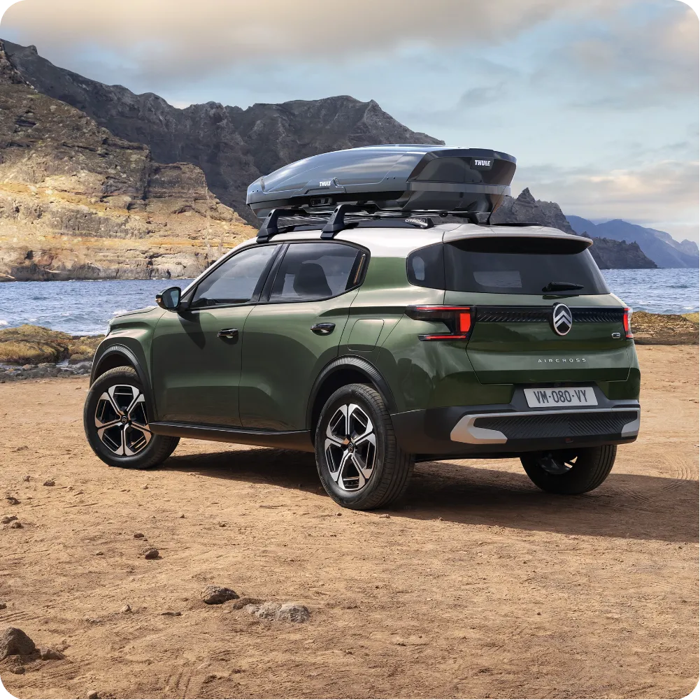 Vista exterior do SUV elétrico Citroën ë-C3 Aircross com barras de tejadilho e caixa de tejadilho, para uma capacidade de viagem versátil, espaçosa e acessível.