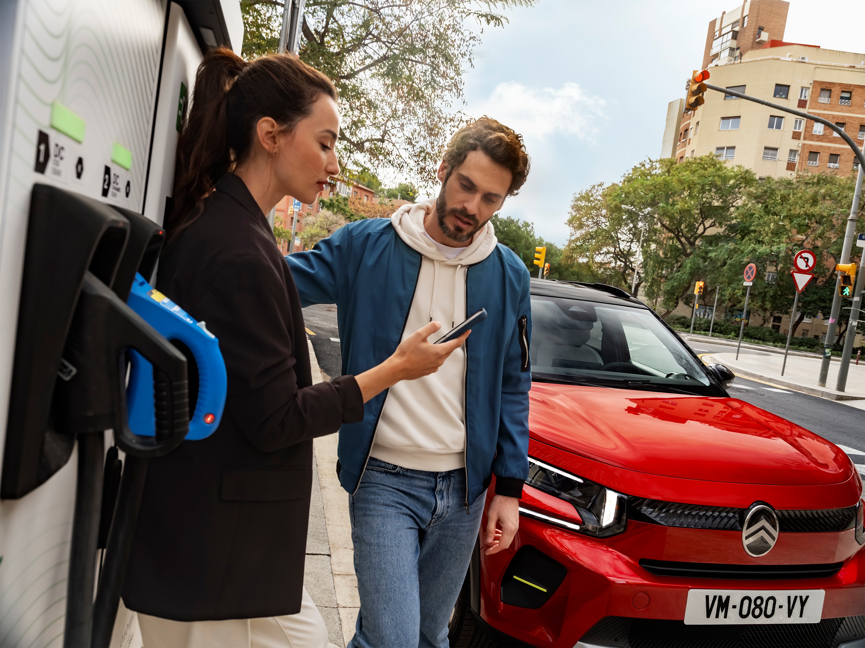 Imagem do Citroën C3 SUV a carregar na rua, com pessoas a prepararem o carregamento rápido para uma mobilidade urbana conveniente, eficiente e acessível.