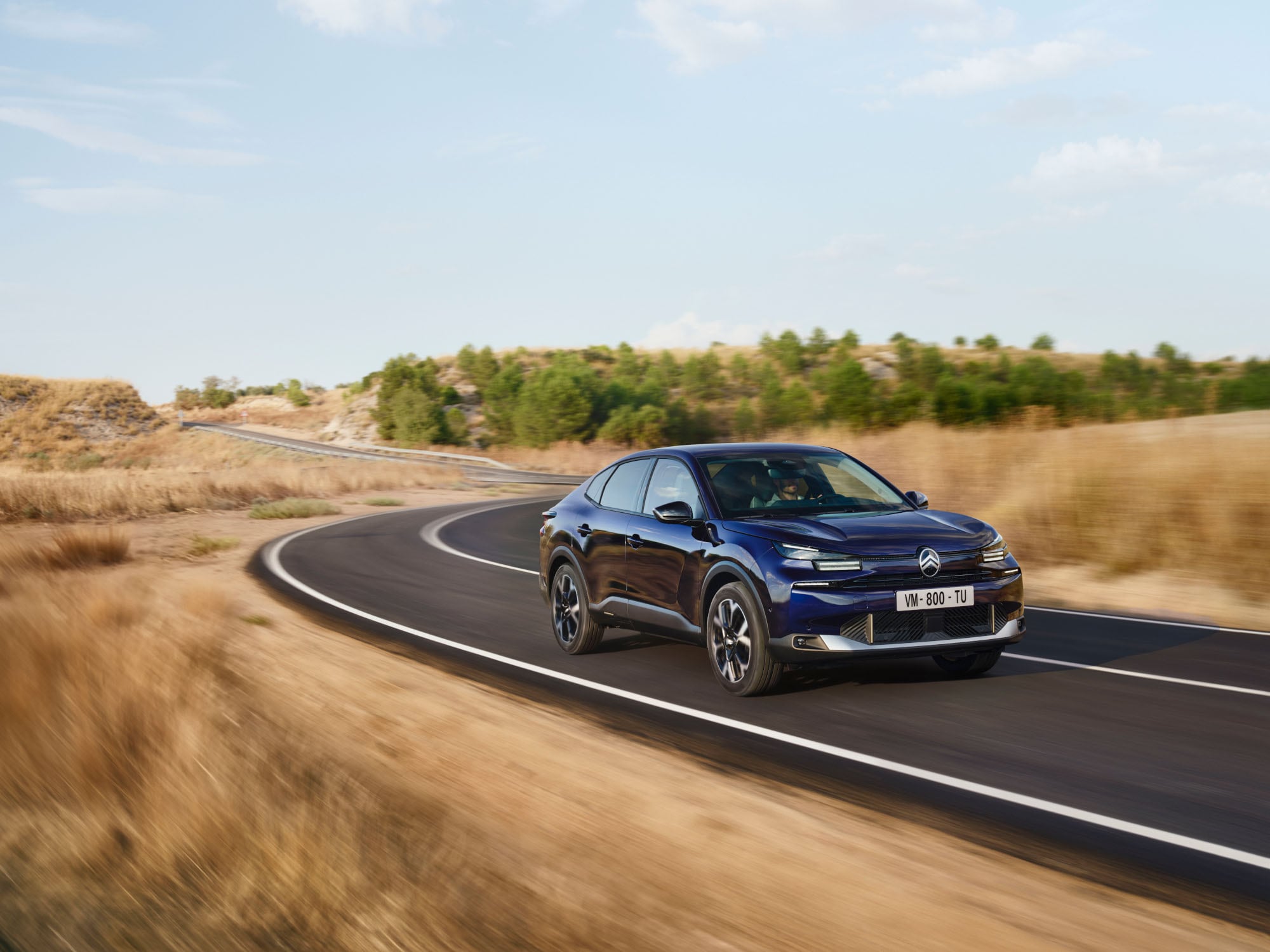 Vista dianteira em três quartos do Citroën C4 X em movimento, evidenciando o seu design fastback ágil para uma mobilidade confiante e acessível.