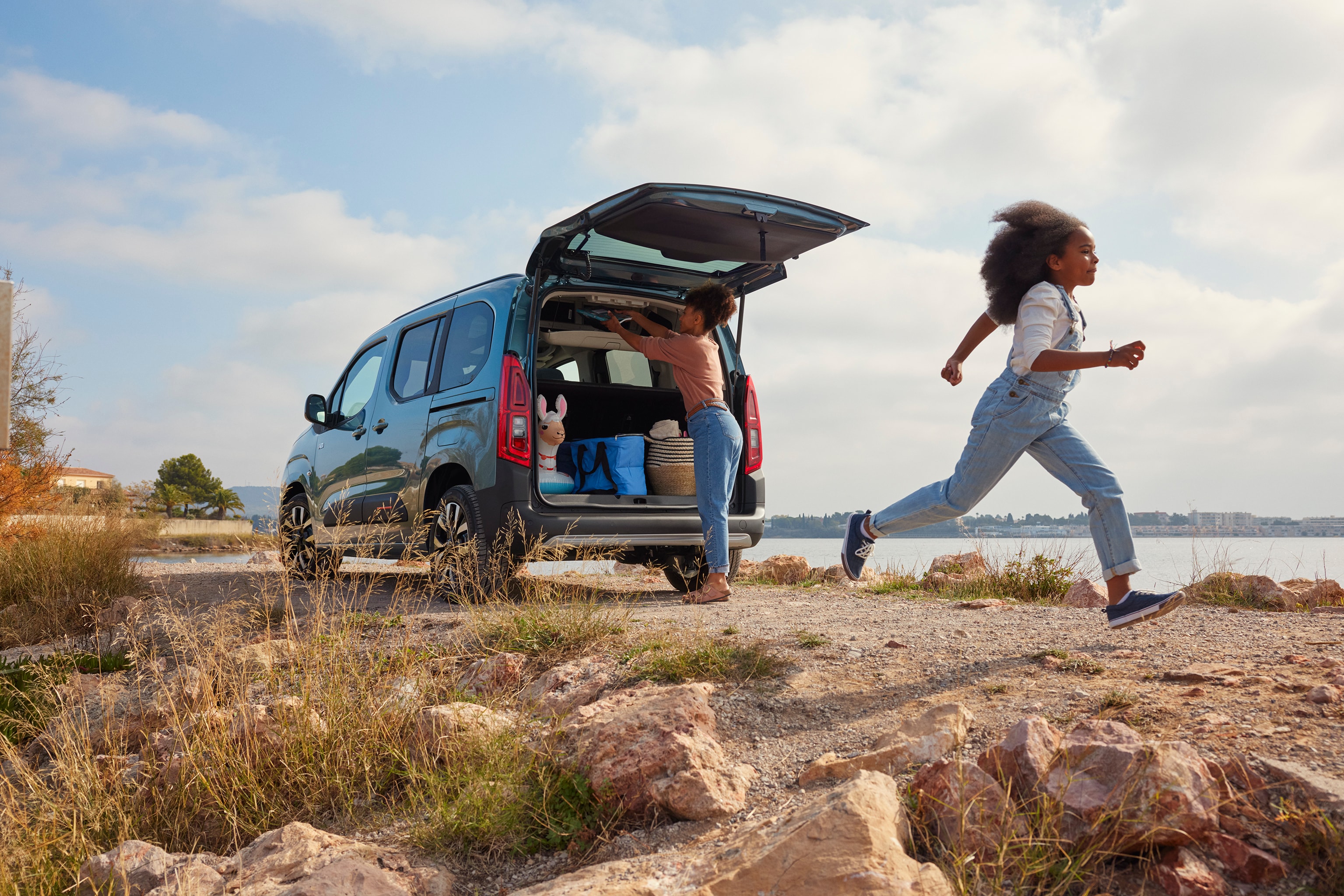 Vista traseira em três quartos do ë‑Berlingo, destacando o amplo acesso à bagageira e a sua versatilidade para utilização familiar.