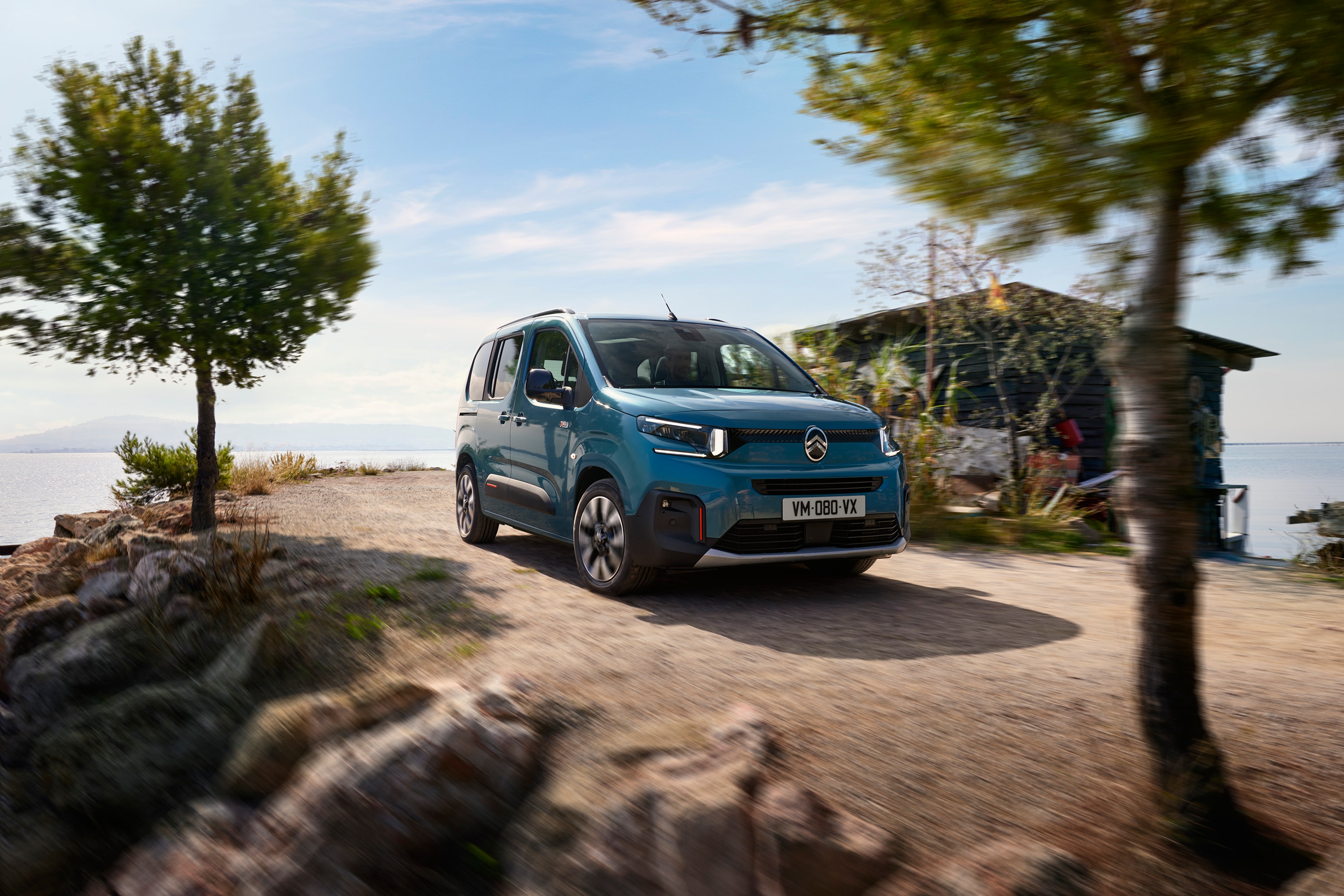 Vista dianteira em três quartos do ë‑Berlingo em Azul Kiama, destacando o design moderno e atrativo, a eficiência e a segurança.