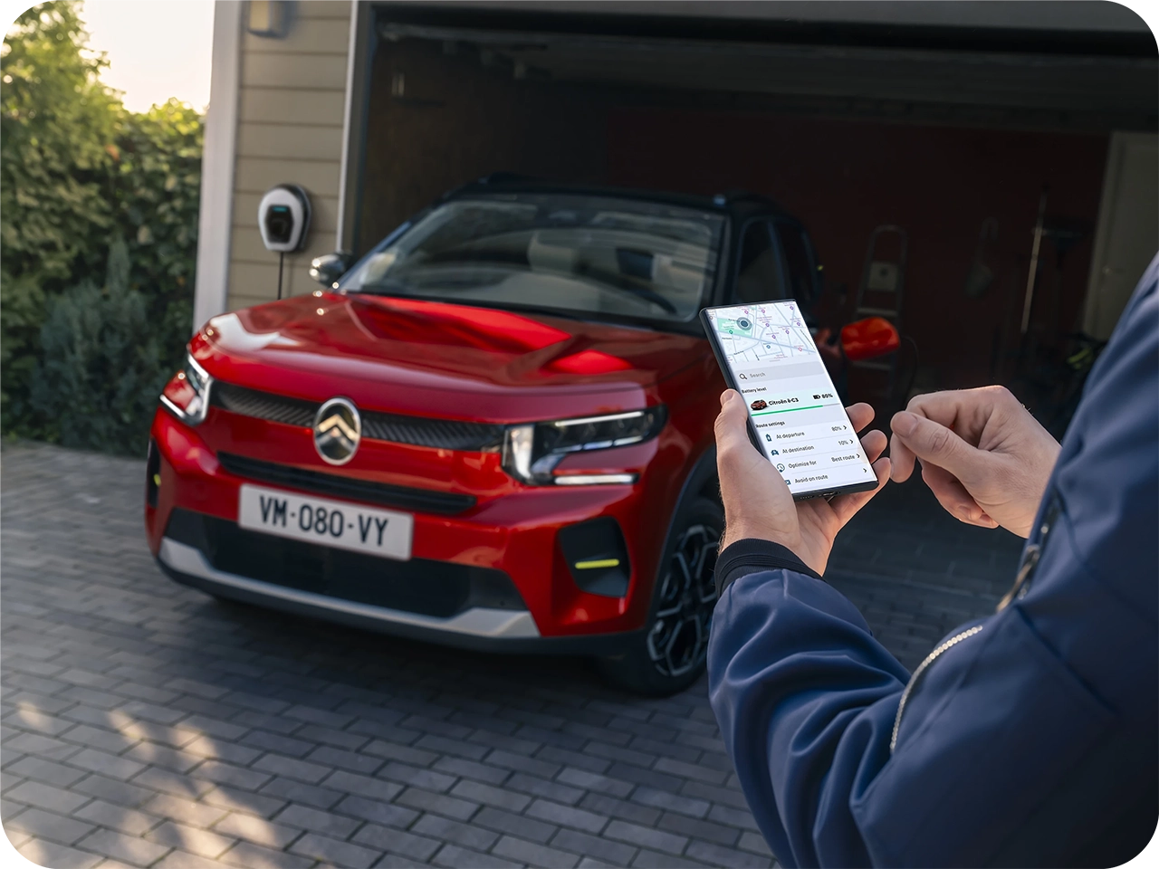 Veículo Citroën estacionado enquanto uma aplicação no smartphone é utilizada para controlar remotamente funções do veículo